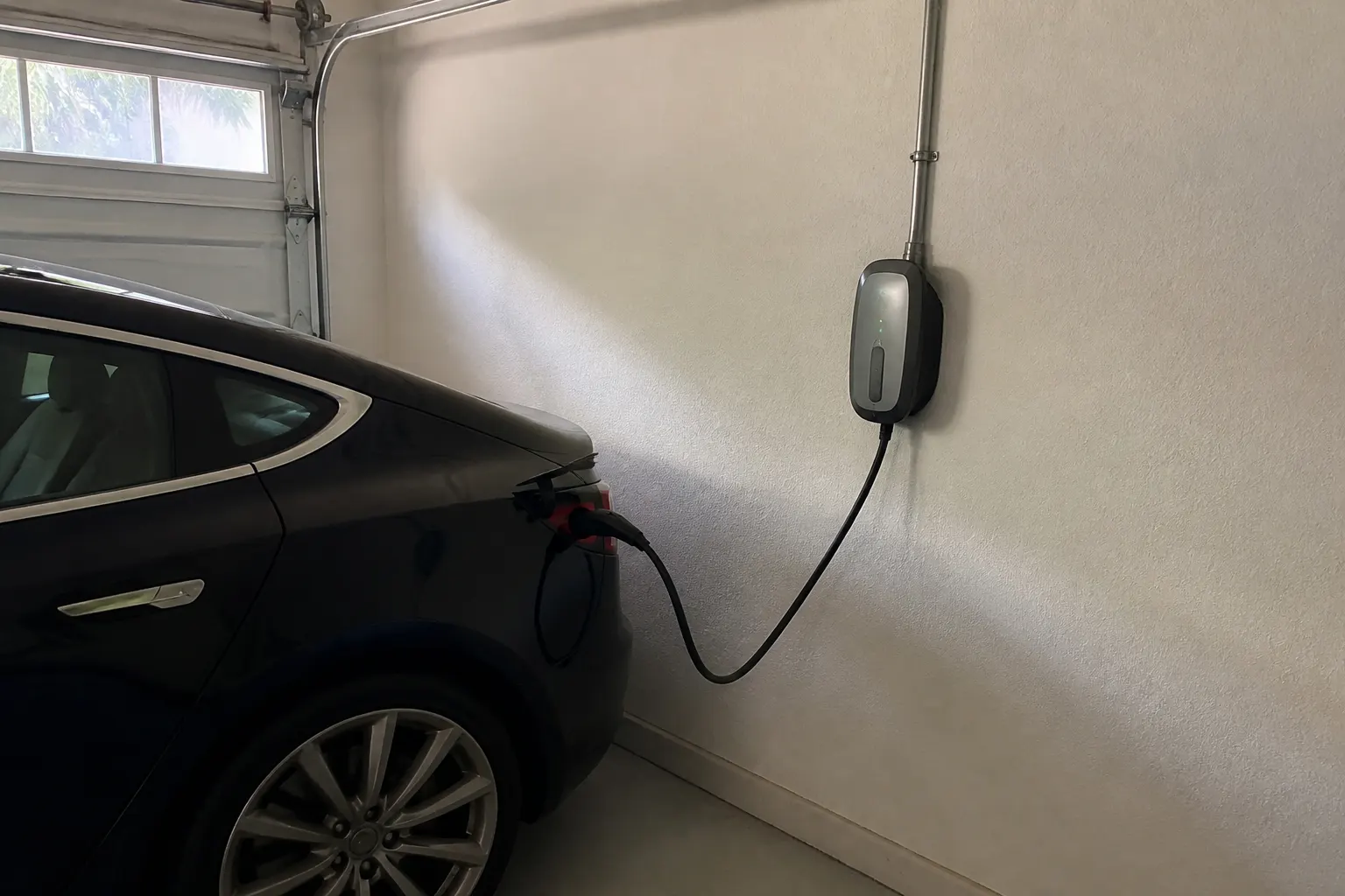 Level 2 EV charger on a Tampa garage wall next to a parked car